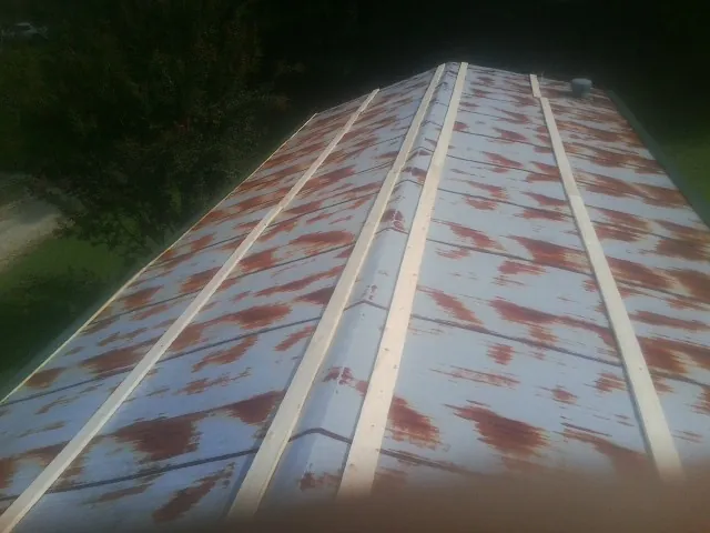 Rusted metal roof panels with new wood purlins before replacement — Storm Damage Roof Repair in Adrian by Roofing Brothers
